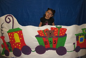 A little girl posing in front of the BSS Christmas train